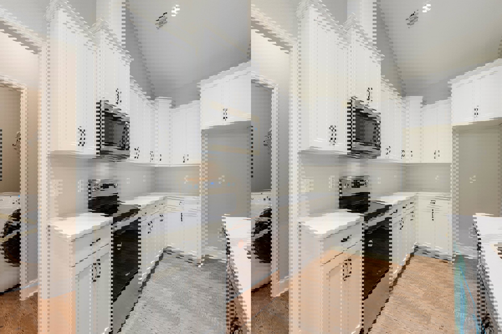 White kitchen cabinets, black appliances including oven and refrigerator, stainless steel sink set in light countertop, microwave built into cabinetry, close-up of black plate on