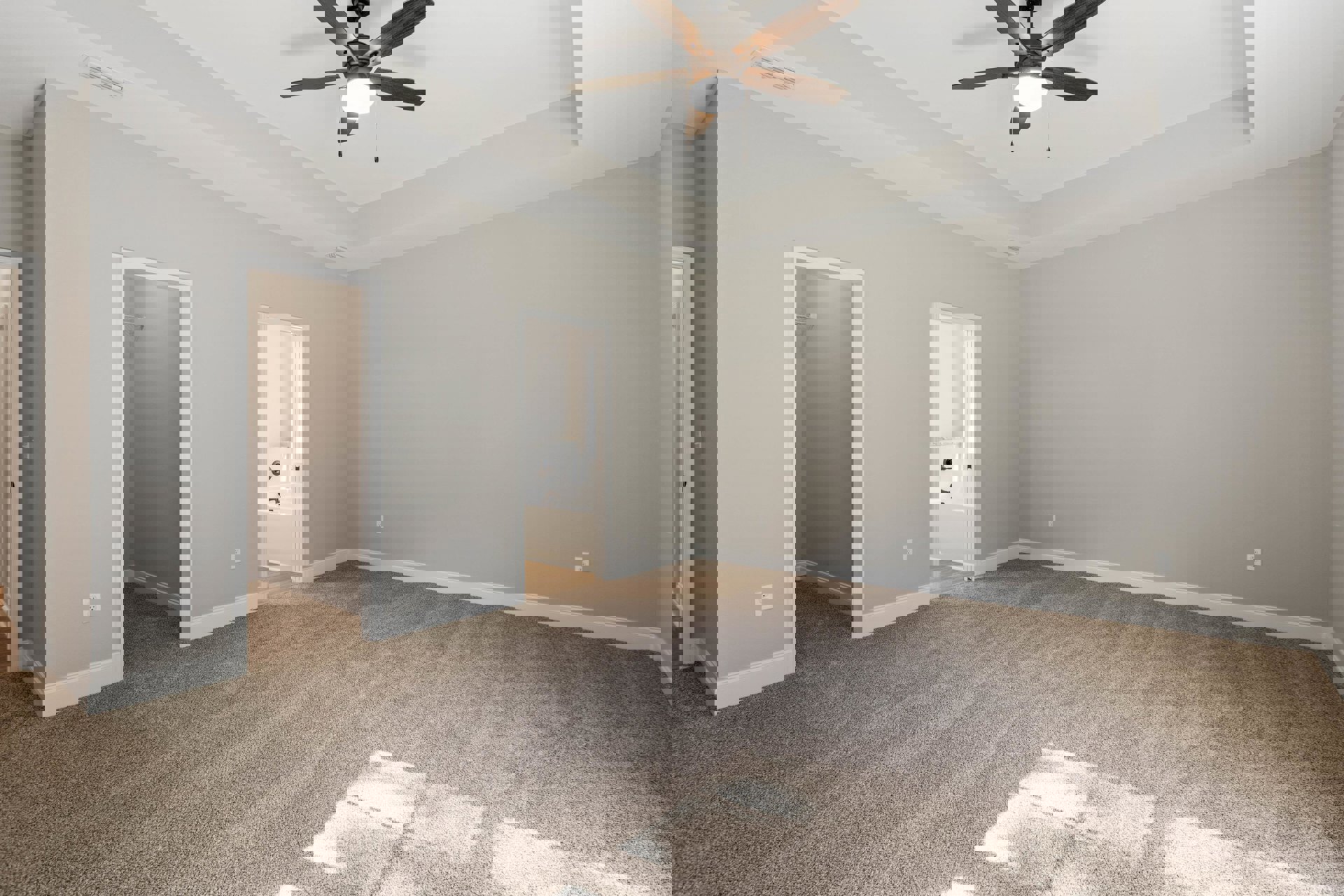 Carpeted bathroom with ceiling fan, freestanding bathtub near window, white walls, door with chrome knob, natural light illuminating floor