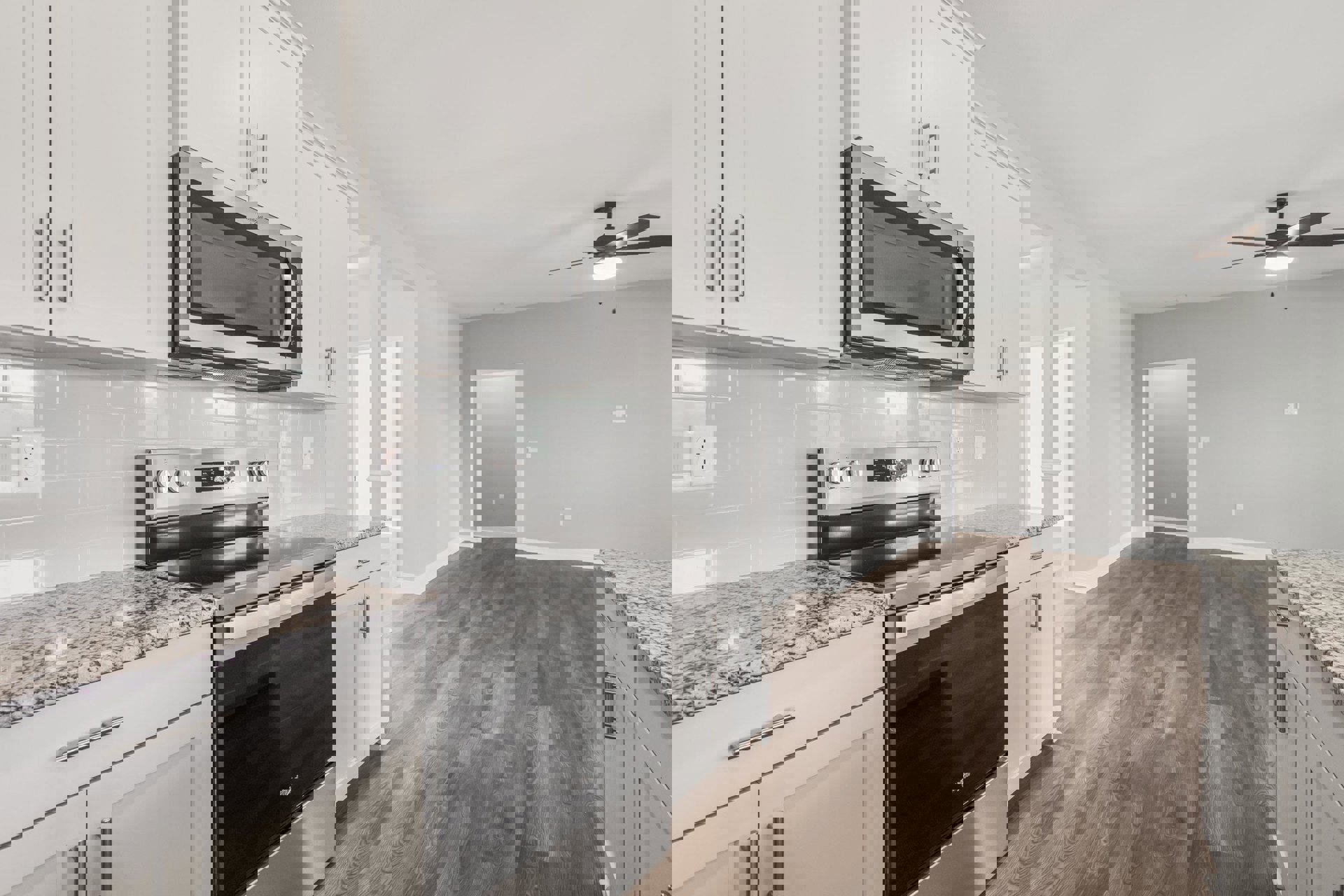 White shaker cabinets, stainless steel microwave and oven, light quartz countertop, silver hardware, white door with wall switch