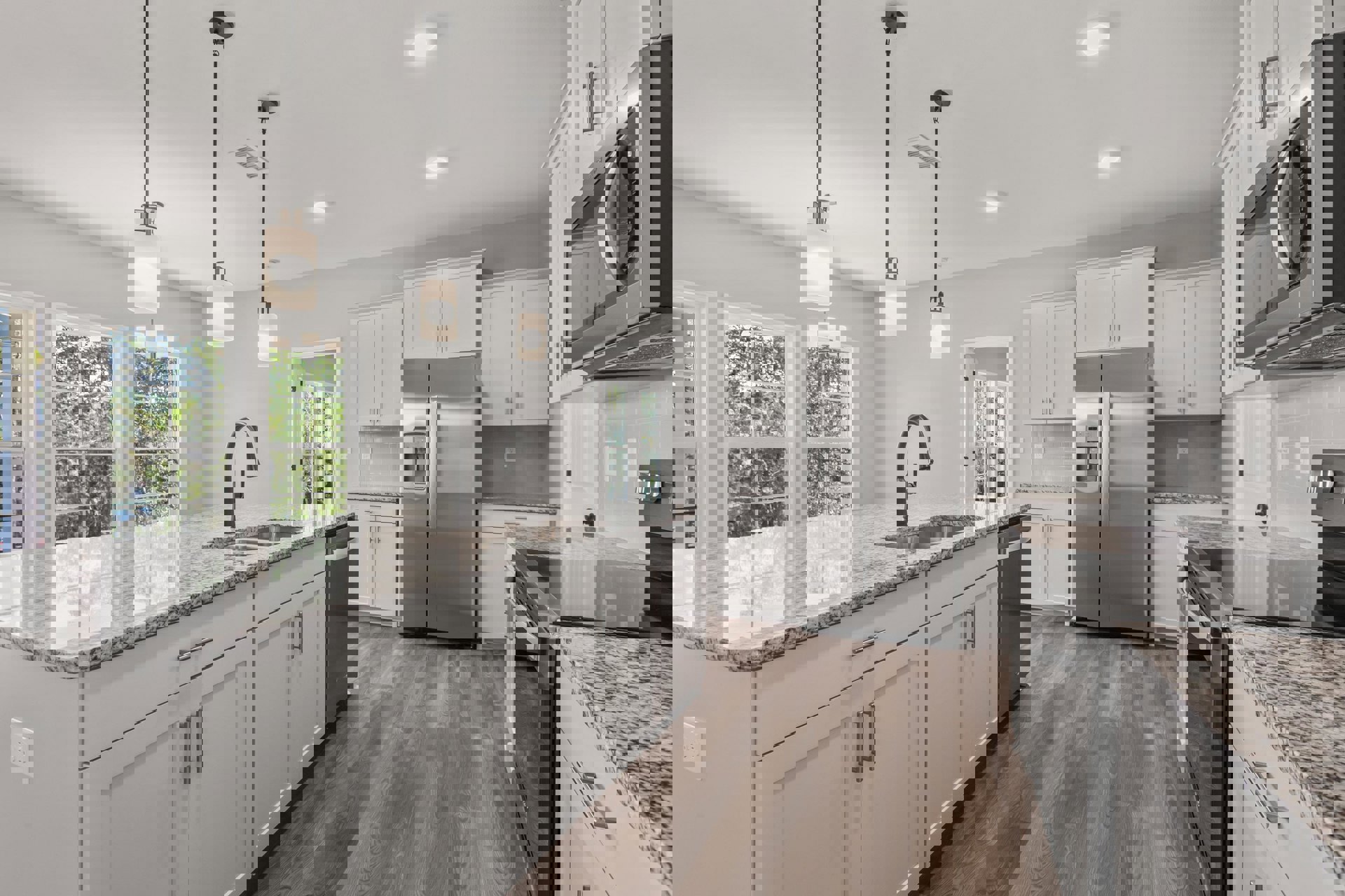 White kitchen cabinets, stainless steel refrigerator with ice and water dispenser, built-in microwave, light fixture with white circular shade, neutral countertops, tile flooring