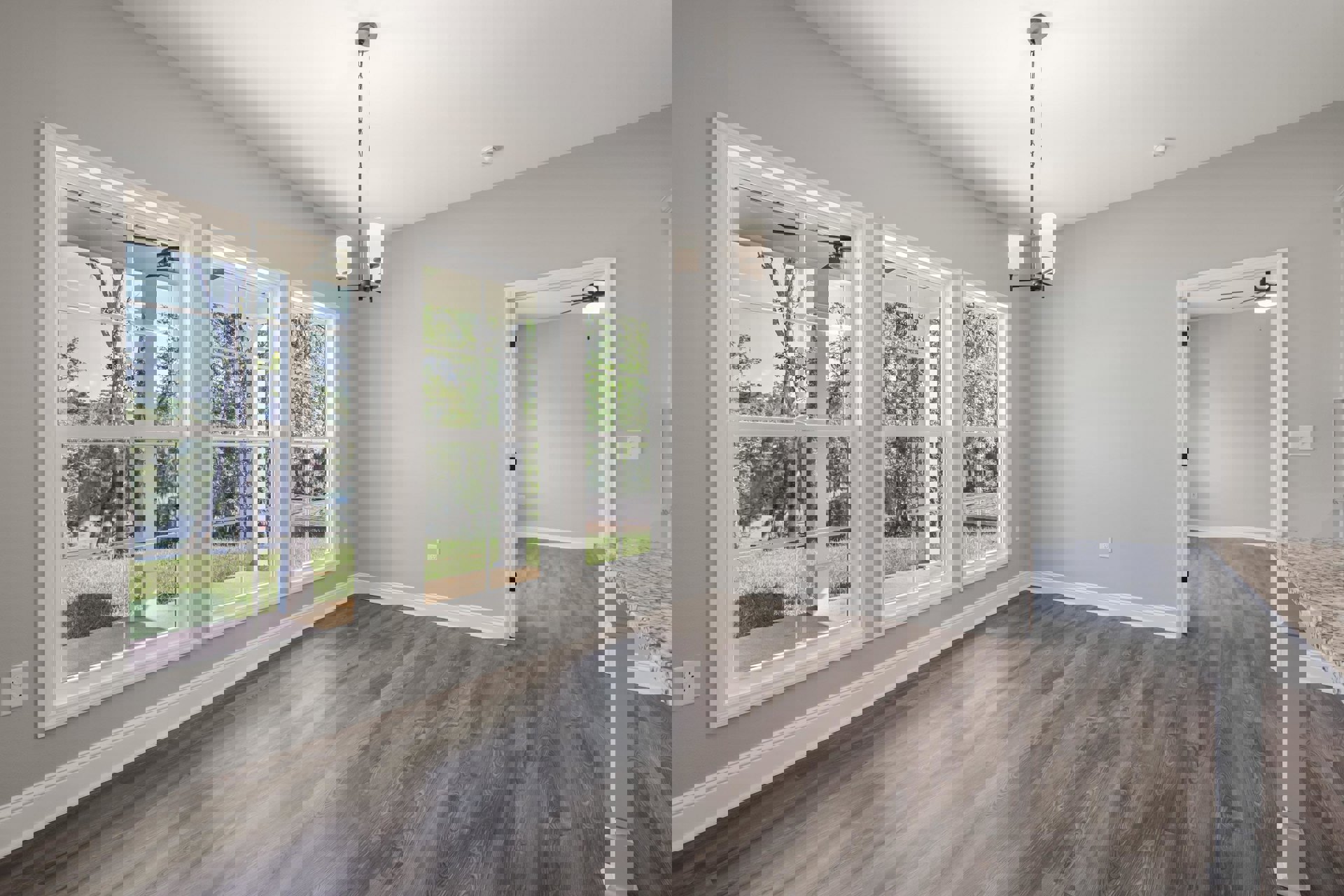 Sunlit room with wide wood plank flooring, plaster walls, and a row of large windows overlooking trees and a pond