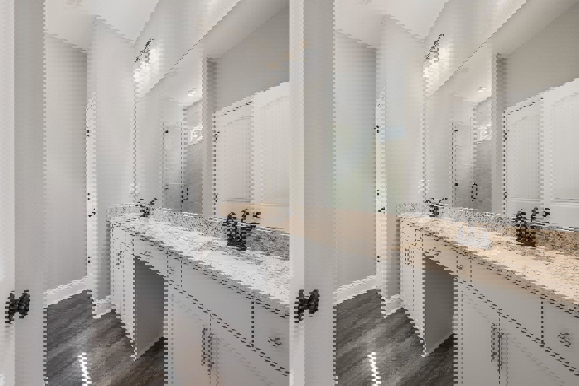 Bathroom with double vanity featuring white sinks, quartz countertop, large framed mirror, modern chrome faucets, white cabinetry, and neutral tile flooring