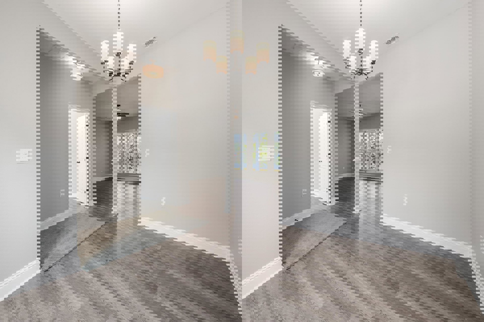 Wood floor room featuring a patterned rug, white door with black knobs, chandelier, white lamp with black base, and light switch on plaster wall