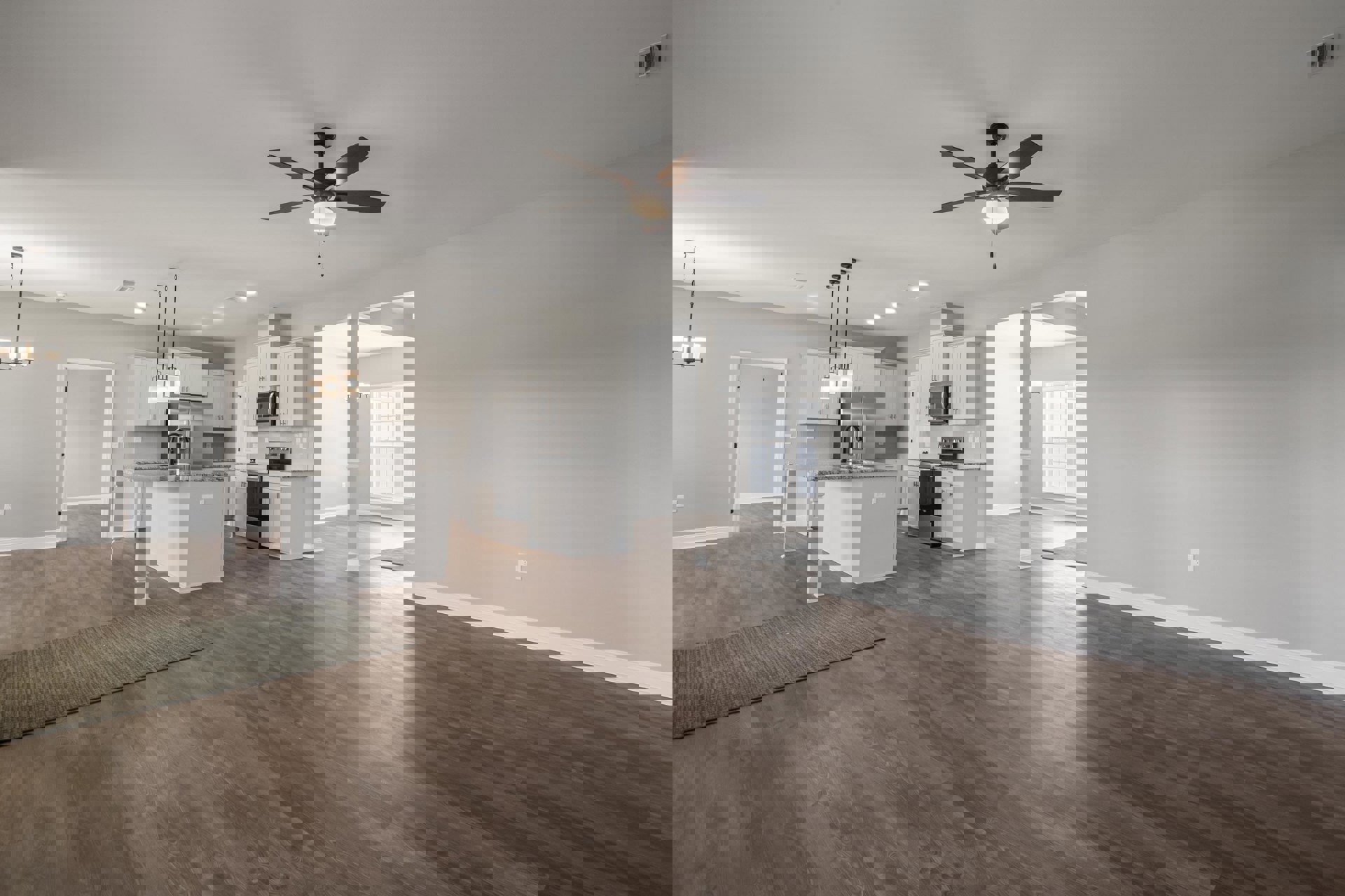 Open concept kitchen and dining area with laminate wood flooring, ceiling fan with light, open microwave door, glass patio door, and patterned rug.