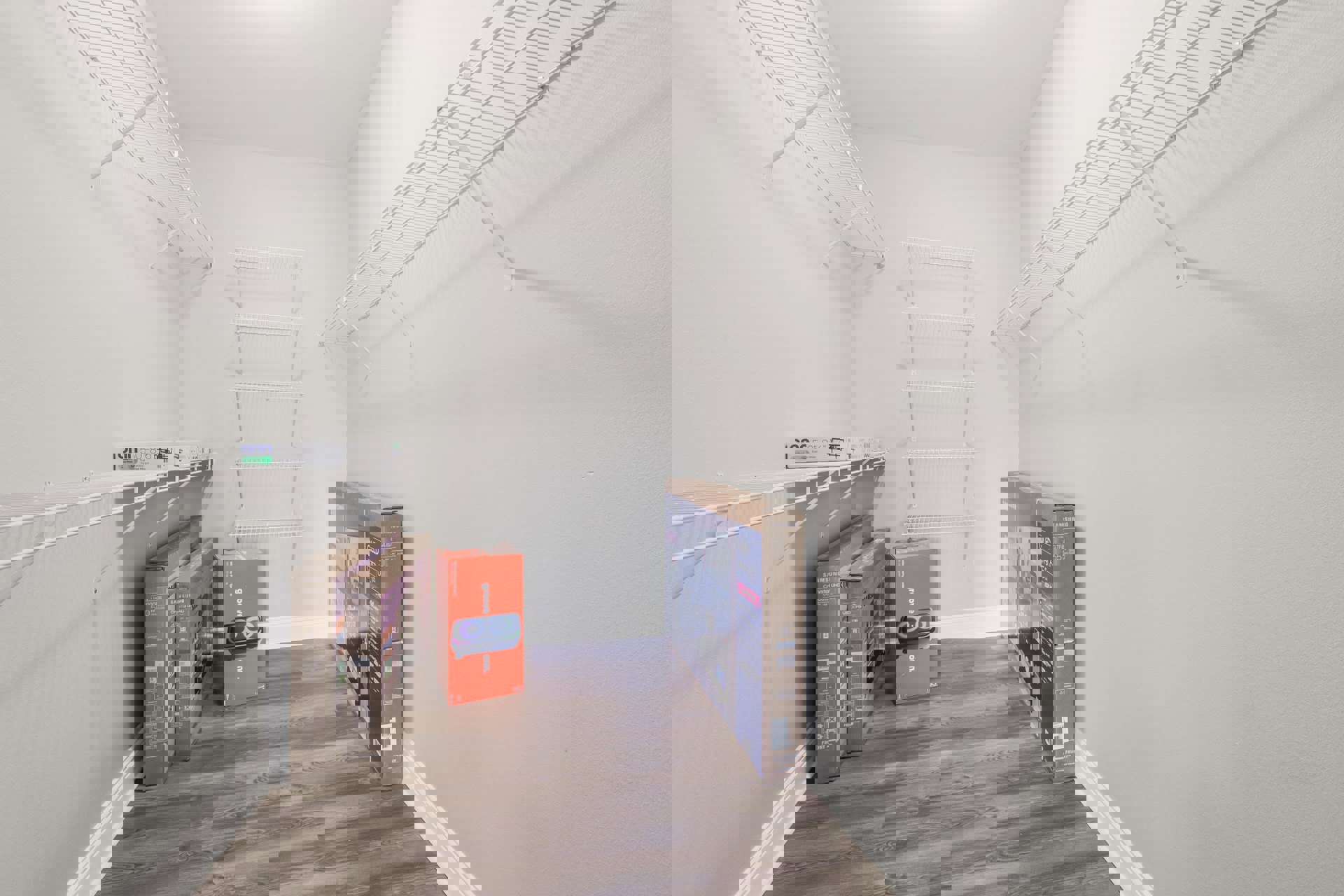 Shelving unit filled with assorted cardboard boxes, some featuring printed images of electronics and people, set against plaster walls and auburn flooring in a residential