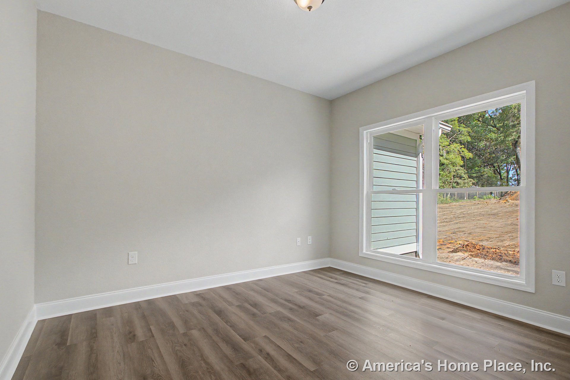 Large double window with white trim allows natural light into bedroom with light gray painted walls, white baseboard trim, wood-look vinyl plank flooring, ceiling-mounted light