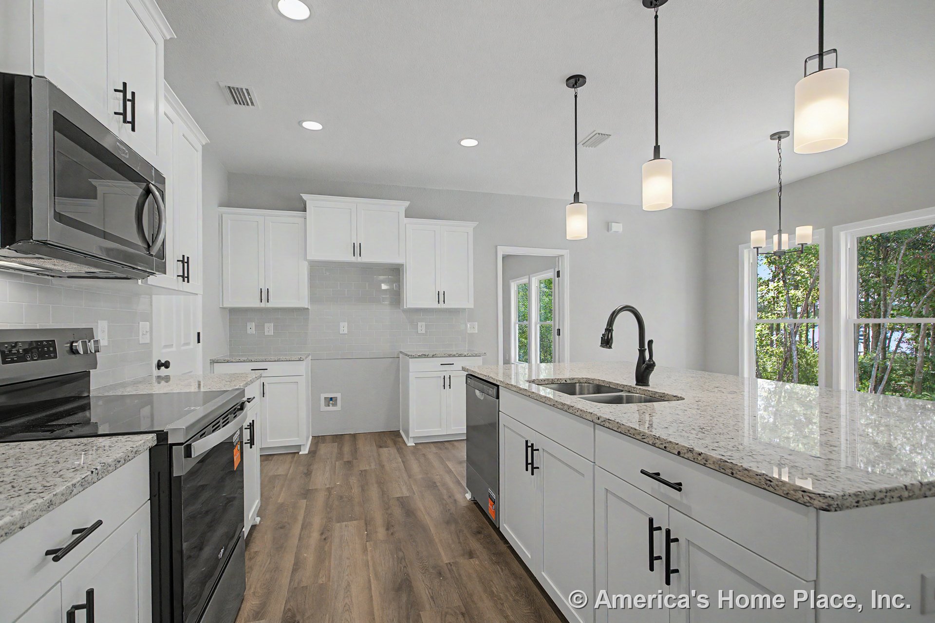 White shaker cabinets, granite countertops, and stainless appliances in a kitchen with wood-look flooring, subway tile backsplash, pendant and recessed lighting, double sink, and