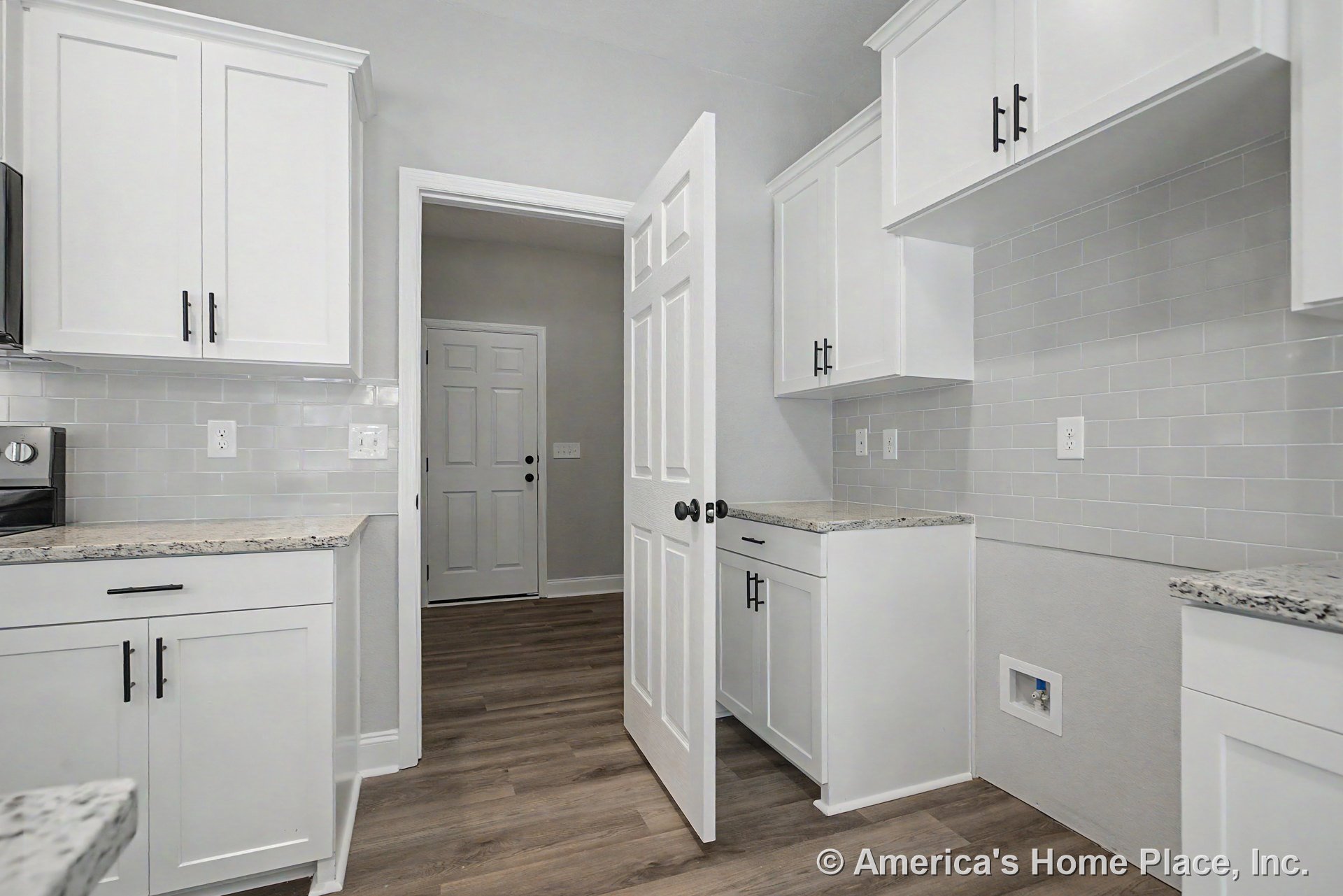 White shaker cabinetry with brushed hardware, granite countertops, light subway tile backsplash, wood-look flooring, multiple electrical outlets, panel interior doors, and neutral
