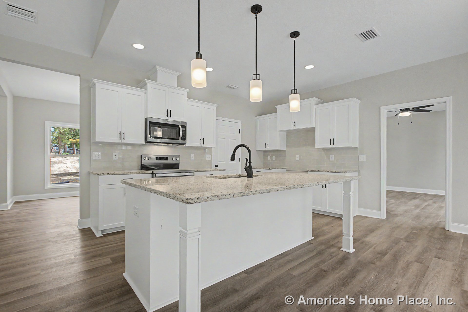 White shaker cabinets, granite island countertop with pendant lighting, stainless steel appliances, tile backsplash, built-in microwave, wood-look flooring, recessed lighting, and