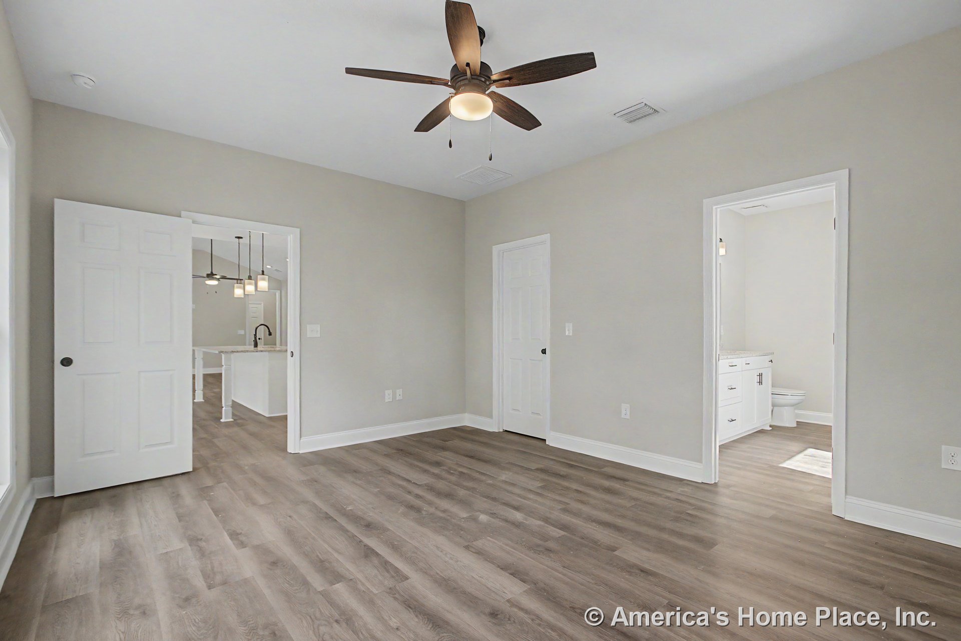 Bedroom with wood-look plank flooring, ceiling fan with integrated light, neutral wall paint, white interior doors, baseboard trim, and open layout providing direct access to