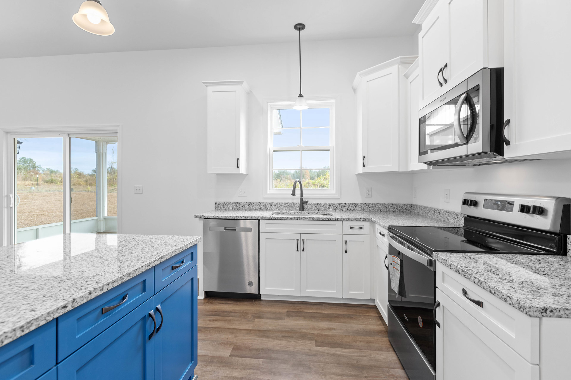 White kitchen cabinets paired with blue countertops, stainless steel dishwasher, glass-door microwave, stove, and overhead lighting fixture