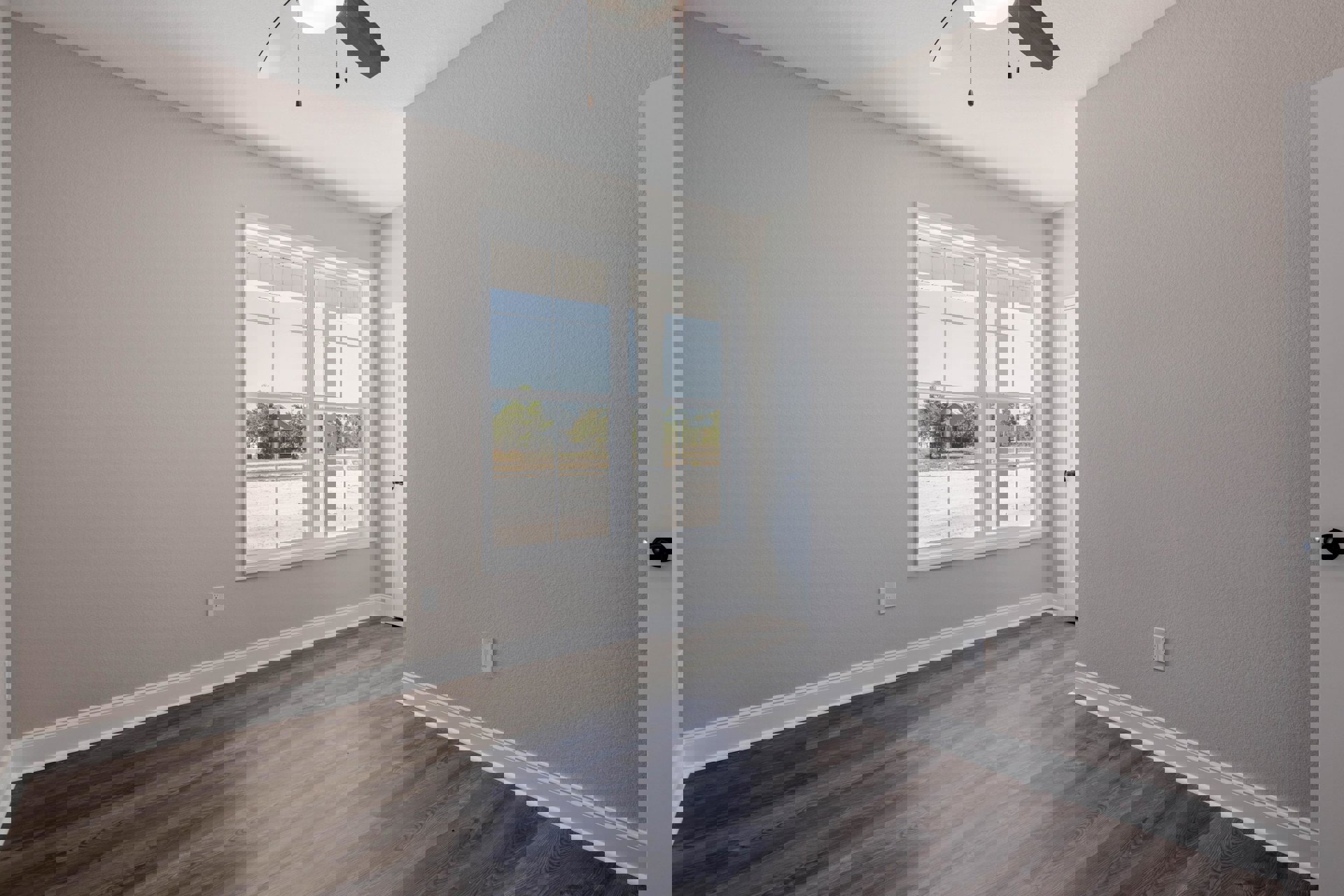 Wood flooring with white trim, white walls, black door, ceiling fan with light fixture, window overlooking neighboring house