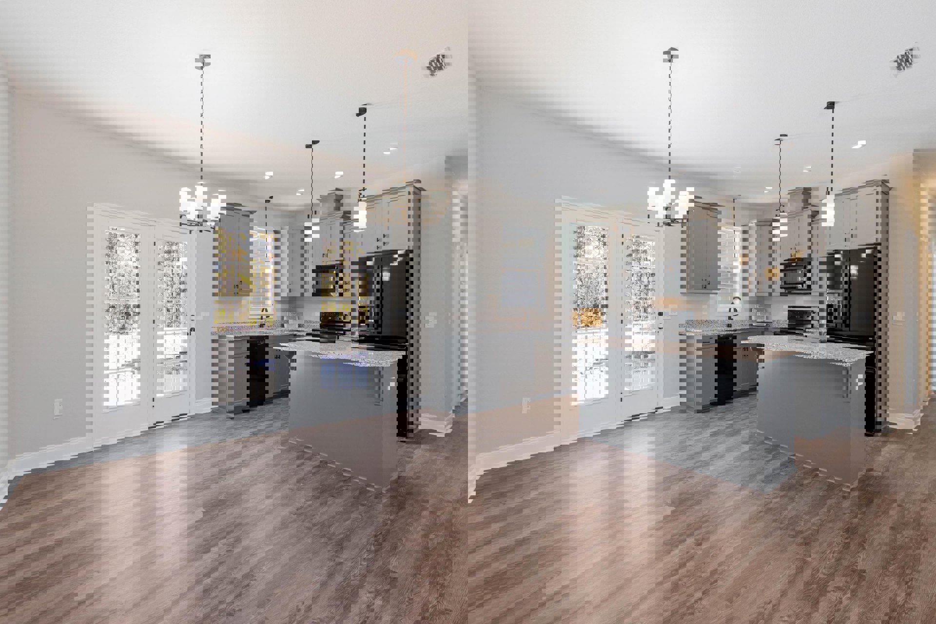 Kitchen with wood flooring, granite countertops, white double doors with glass panes, black microwave, black refrigerator, and marble countertop