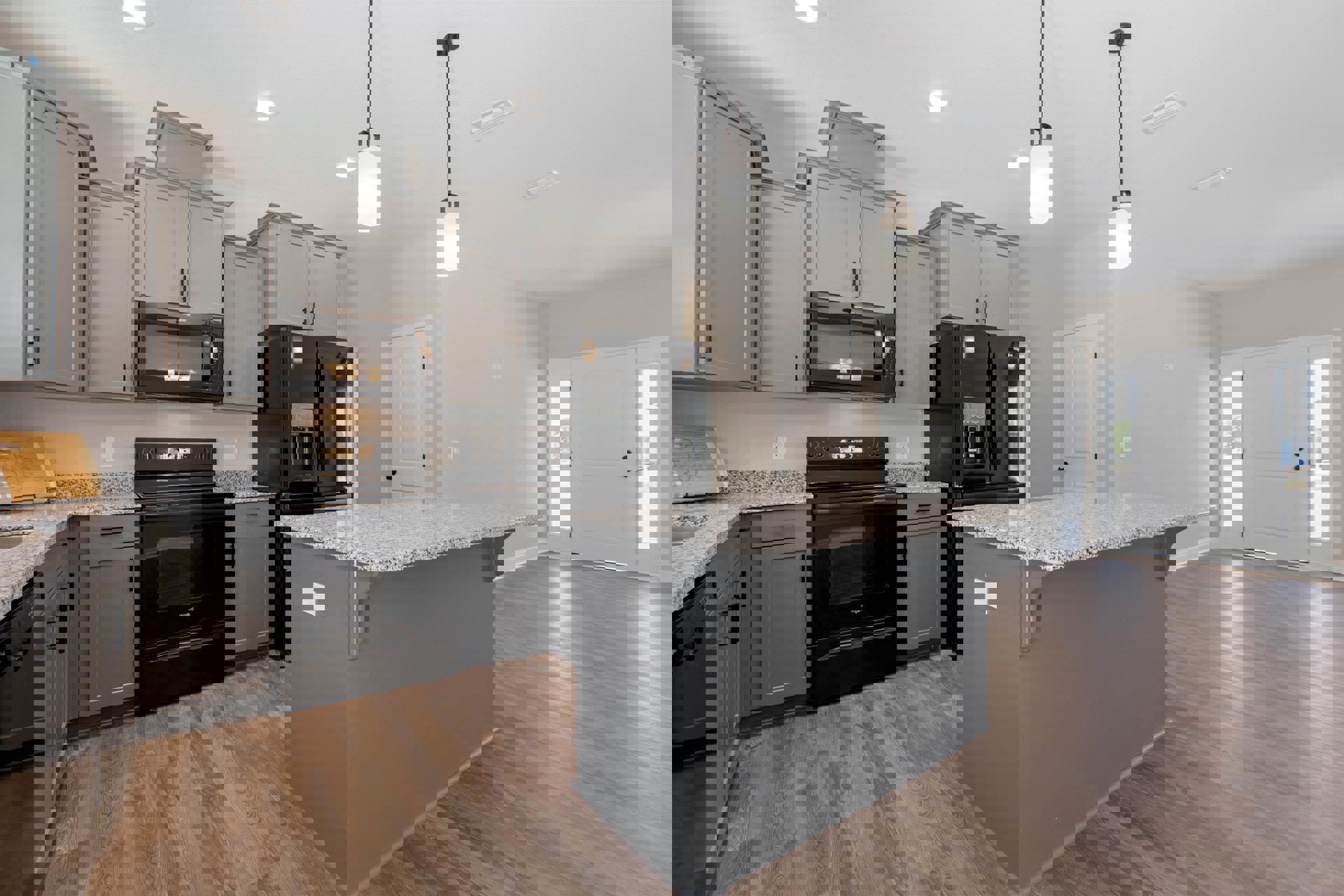 Modern kitchen featuring a marble-topped island, black oven with glass door, black microwave with candles on top, white cabinetry, and a white door with glass windows