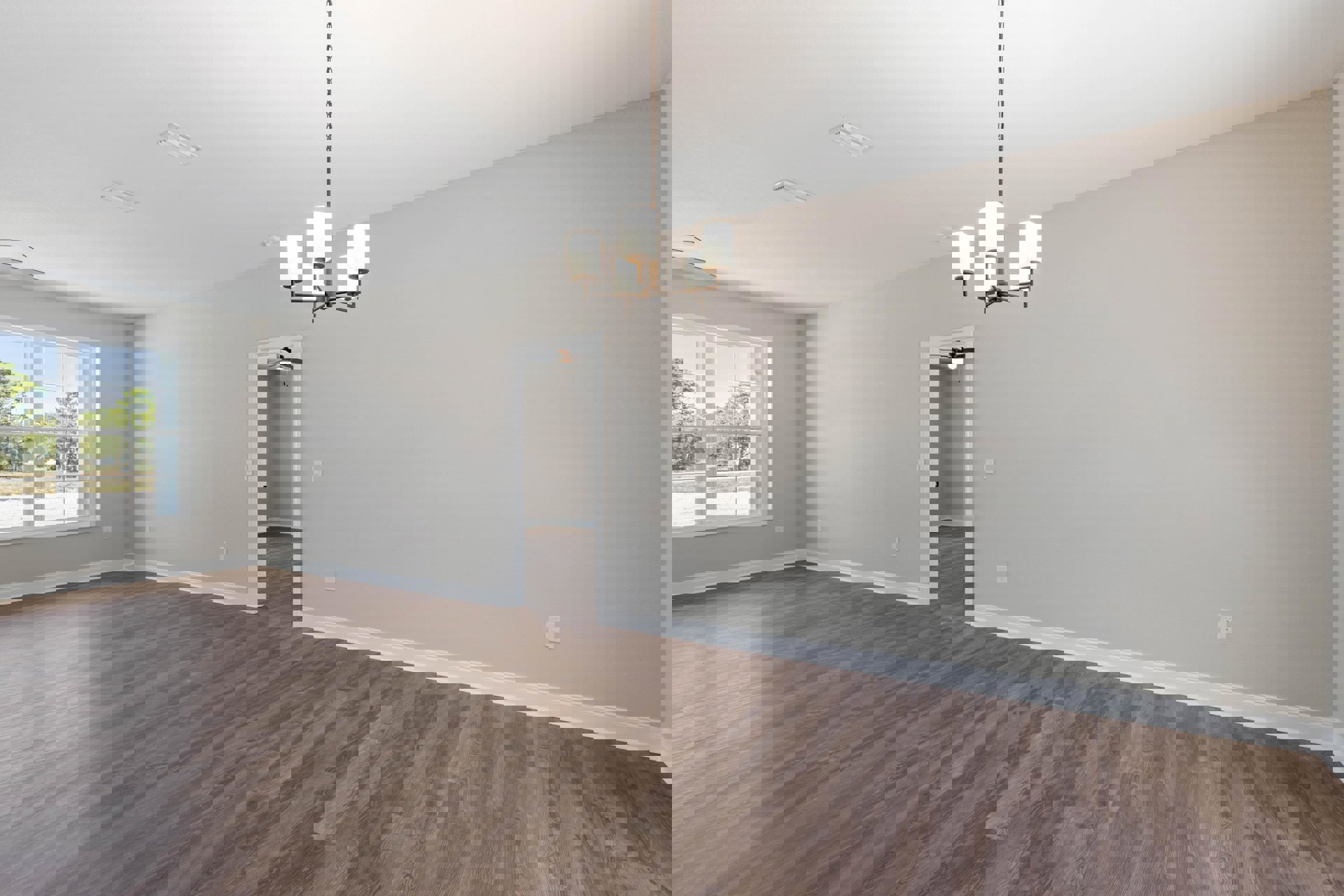 Chandelier hanging from ceiling in a room with hardwood flooring, white baseboards, plaster walls, and large window overlooking leafy trees