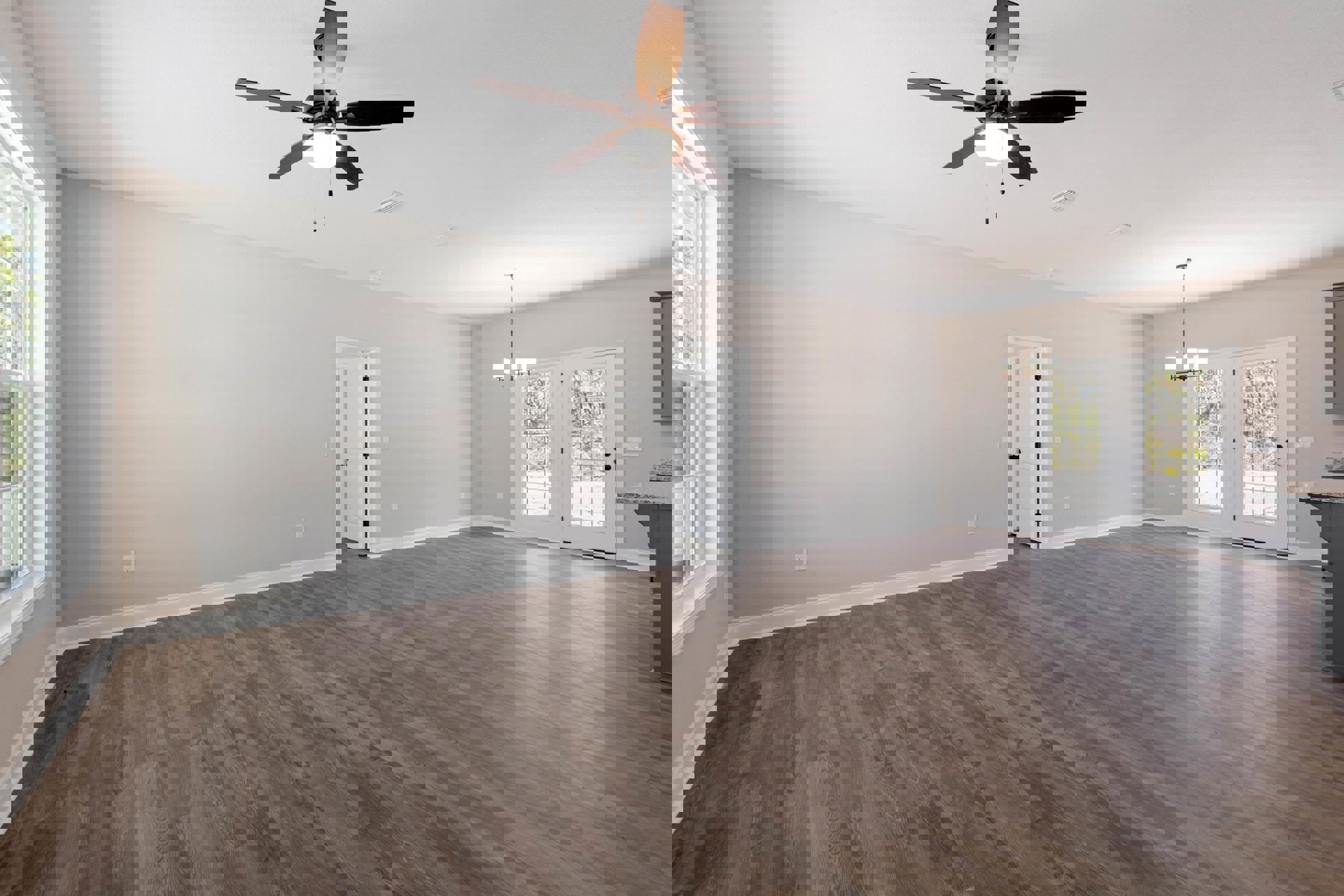 Ceiling fan with light fixture, hardwood flooring, white double doors with glass panes, white walls, black door hardware, large window with trim