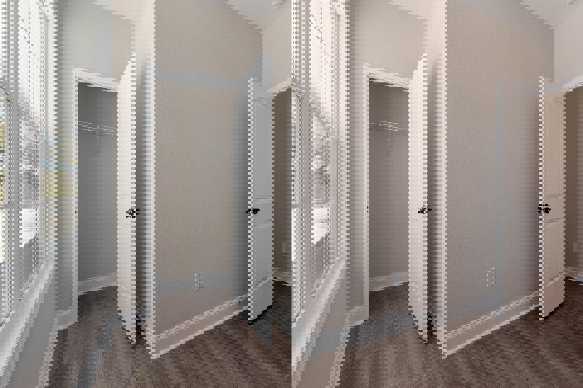 White paneled door with black knob open to a room with laminate flooring, white walls, and a white floating shelf; screened window visible on left.