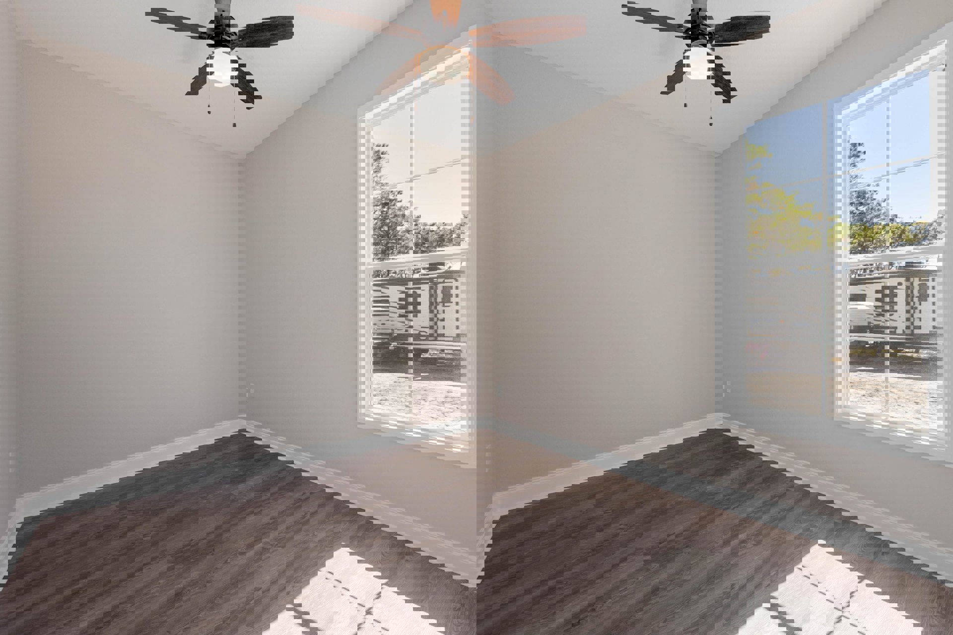 Ceiling fan with integrated light fixture, large window with white trim, wood laminate flooring, neutral painted walls