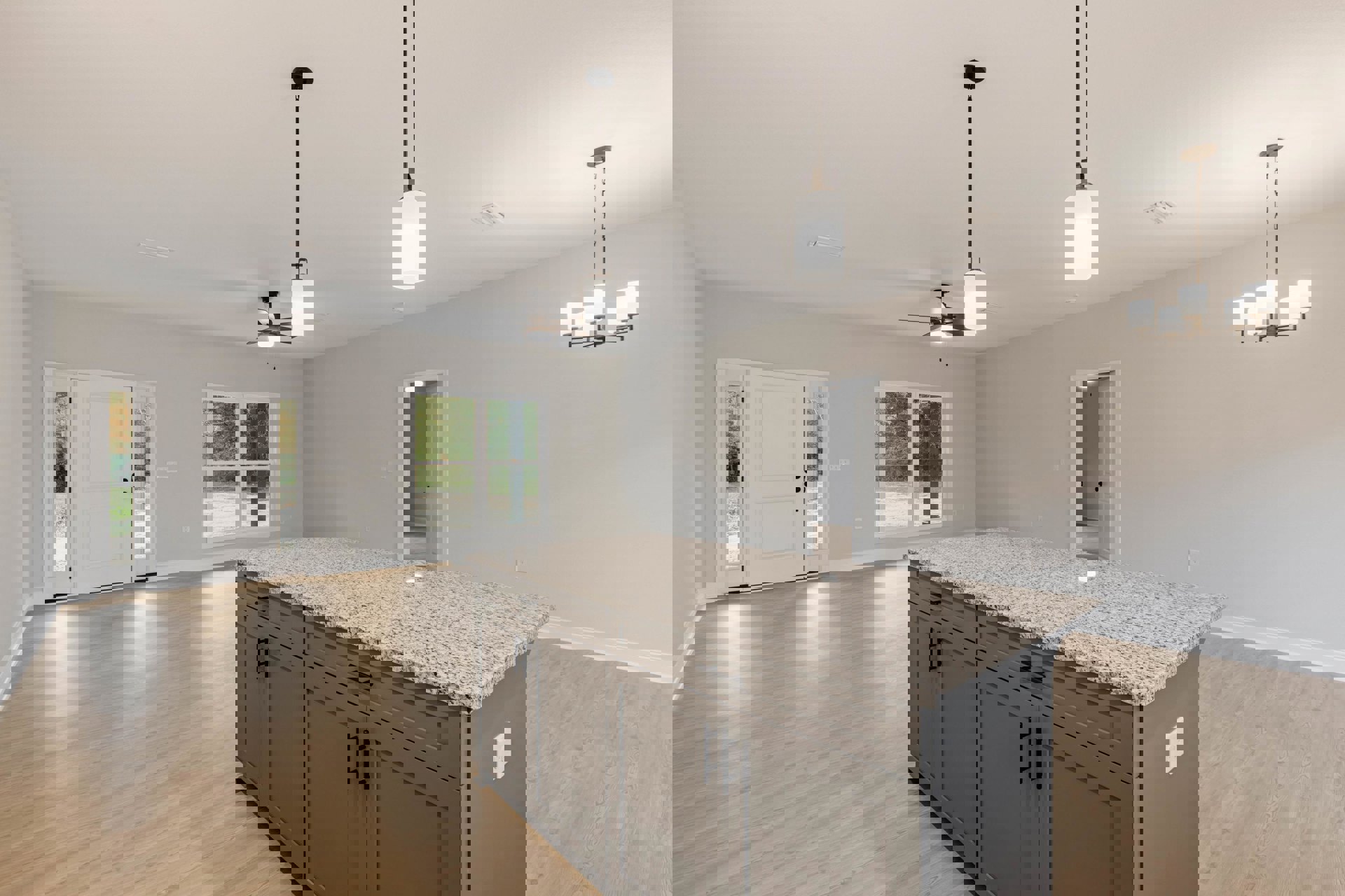 Modern kitchen with light tile flooring, white cabinetry, stone countertop, stainless steel sink, glass-paneled door, and large window overlooking outdoor greenery