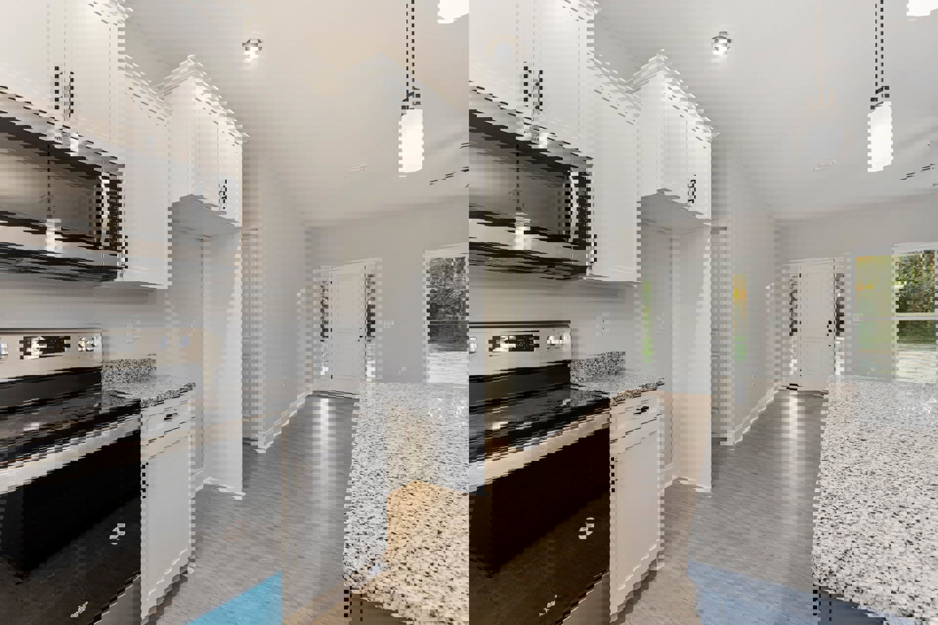 Granite countertops, black stove, white cabinetry, stainless steel microwave, recessed ceiling light, tile flooring, undermount sink