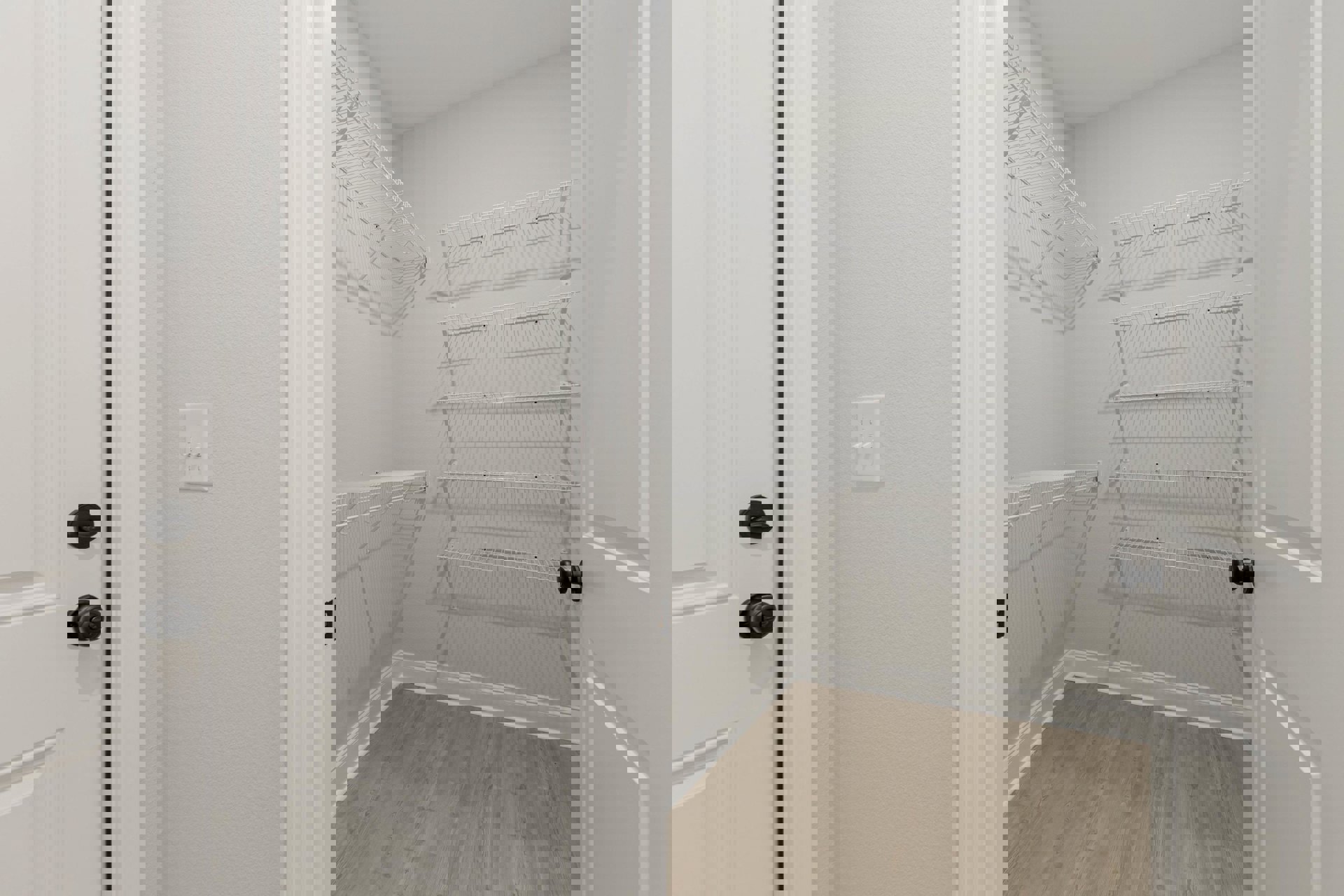 Closet with built-in white shelves, wood flooring with white baseboard trim, black door knob on white door, double white light switch on wall