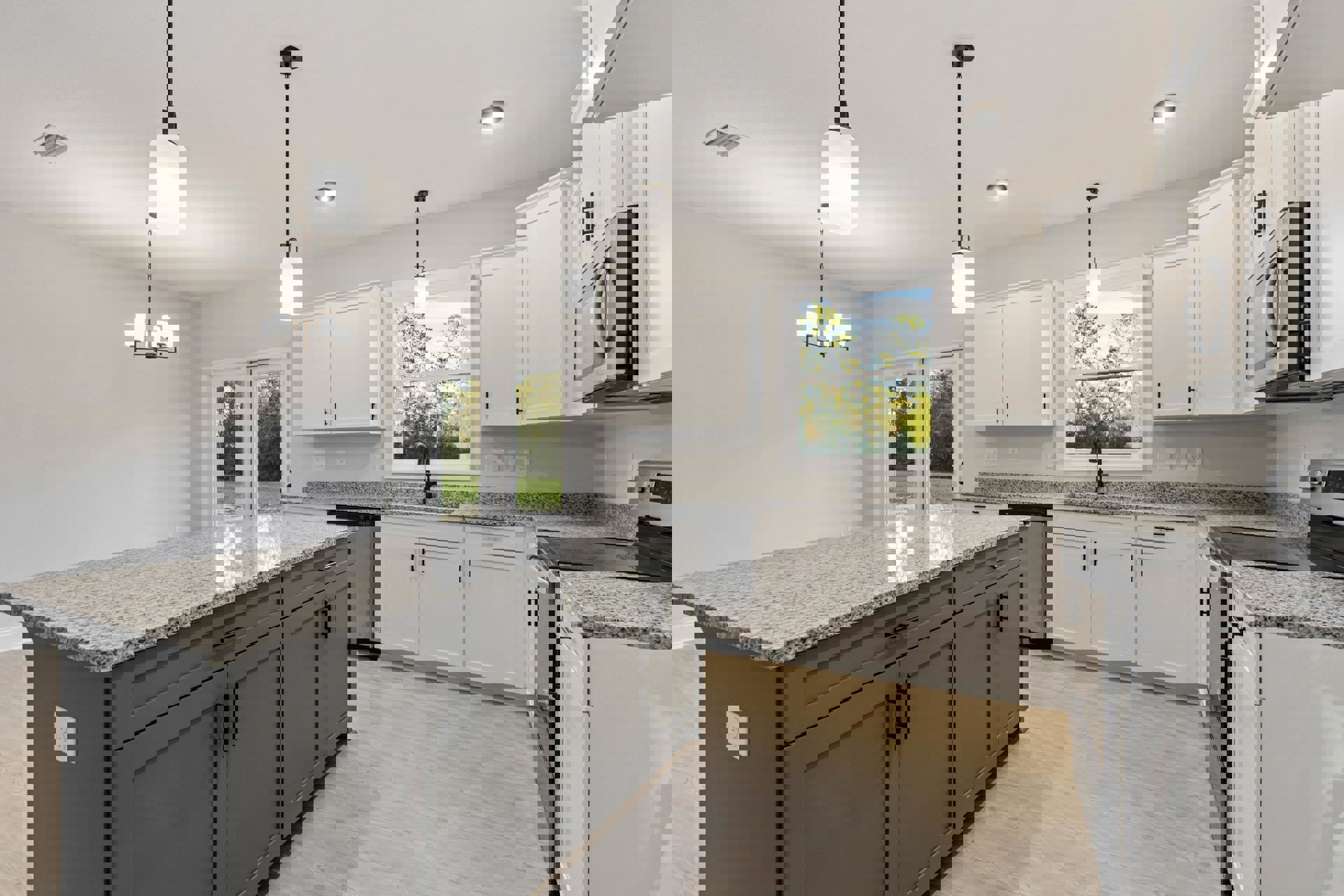 Granite countertops and white cabinetry in a kitchen with stainless steel appliances, window above sink overlooking trees, wall outlet visible near backsplash