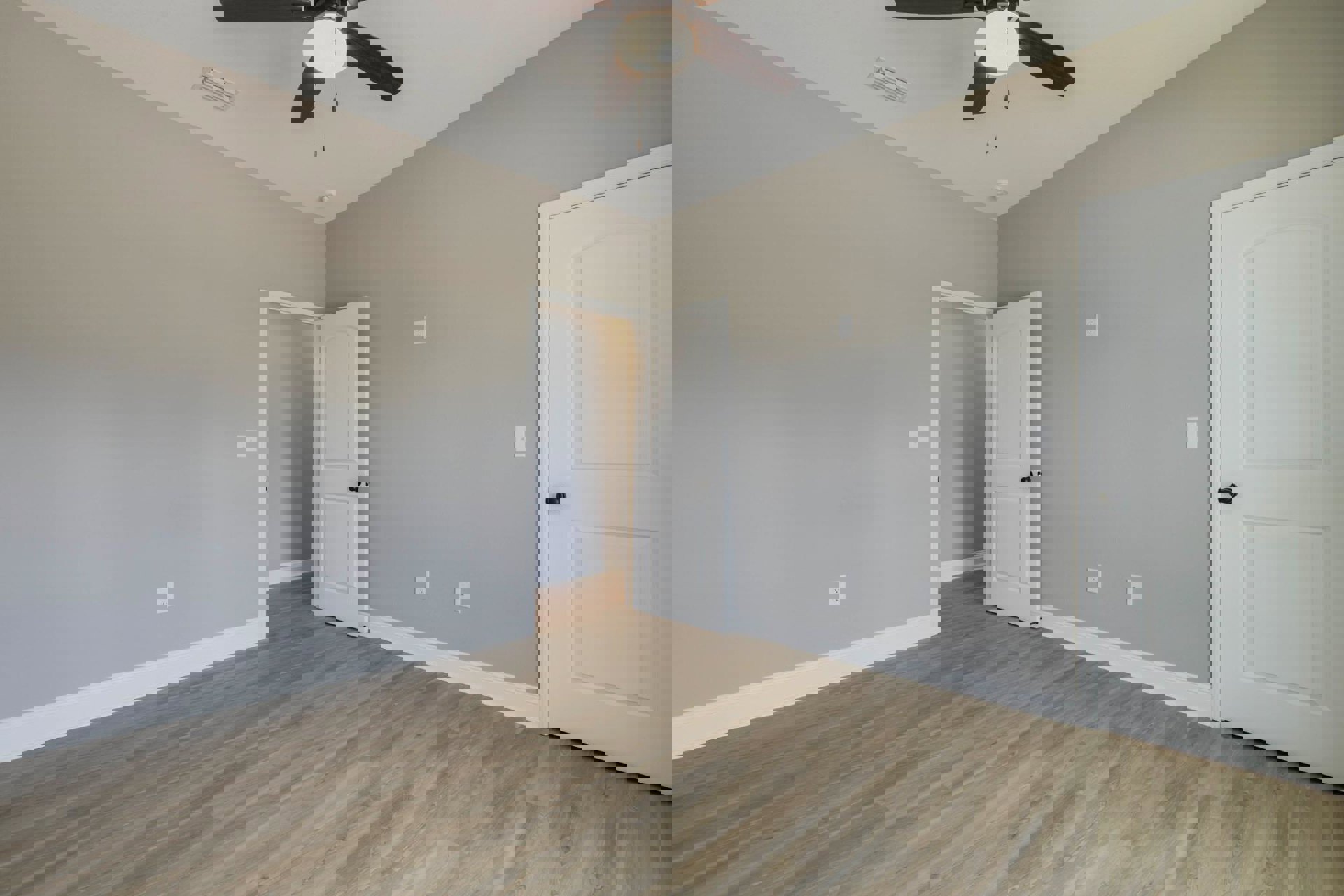 Wood laminate flooring, white walls, white door with black knob, ceiling fan with light fixture, ceiling vent