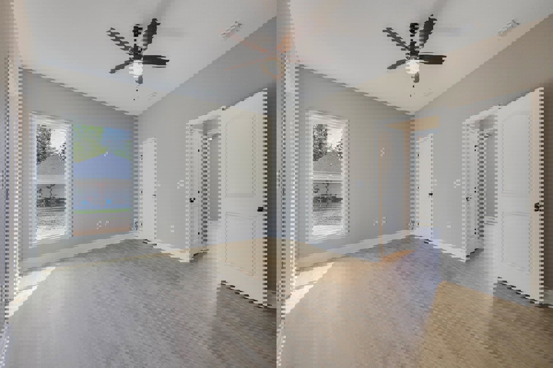 Ceiling fan with light fixture above wood flooring, white door with black knob, neutral walls, window offering exterior view