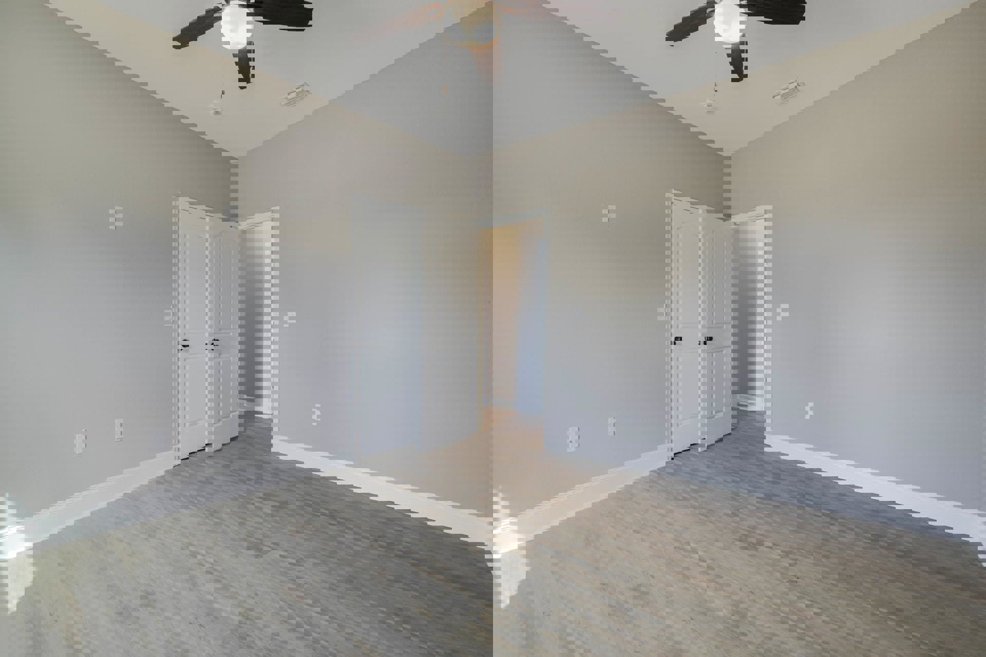 White ceiling fan with light fixture centered in a room featuring wood laminate flooring, white paneled door, and smooth plaster walls.