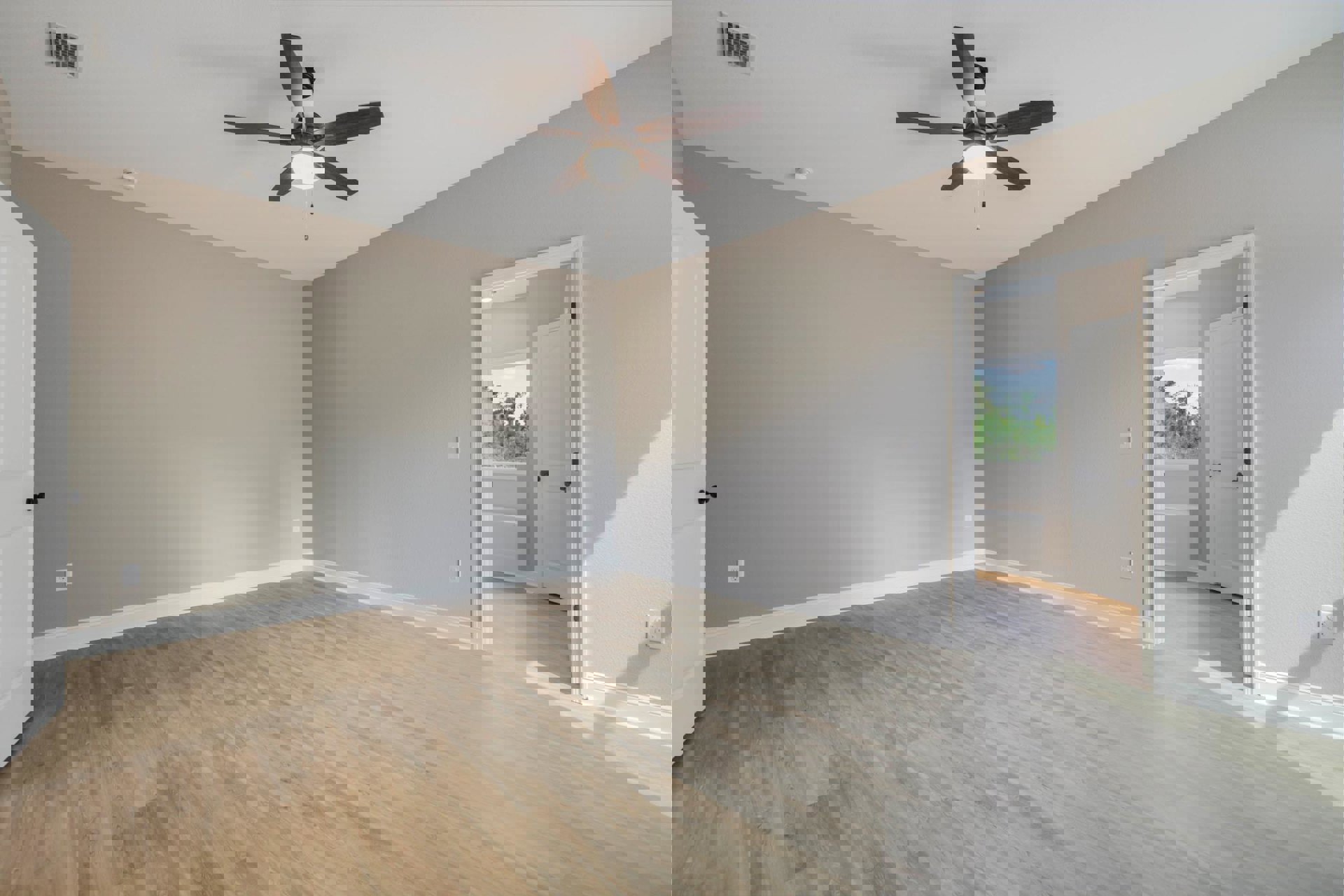 Ceiling fan with light fixture, wood flooring, white walls, white door with black hardware, wall vent