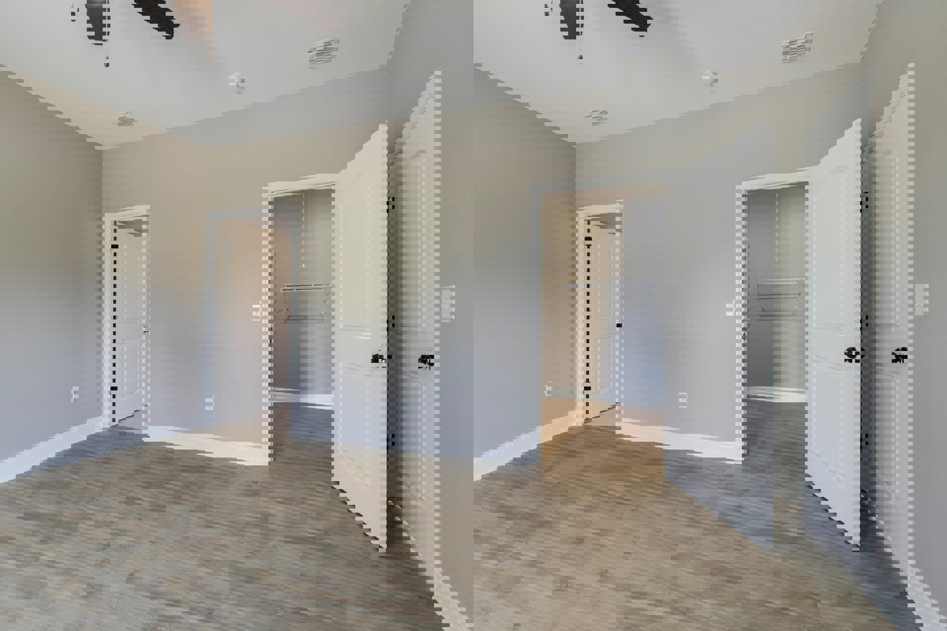 White paneled doors with black handles, wood flooring, white plaster walls, ceiling-mounted smoke detector, and a baseboard heater.