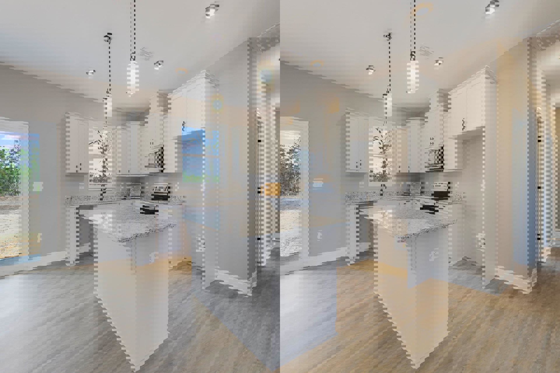 Spacious kitchen featuring a large granite island, white cabinetry, stainless steel sink, built-in microwave, white oven with black knobs, pendant ceiling light, and light fixture