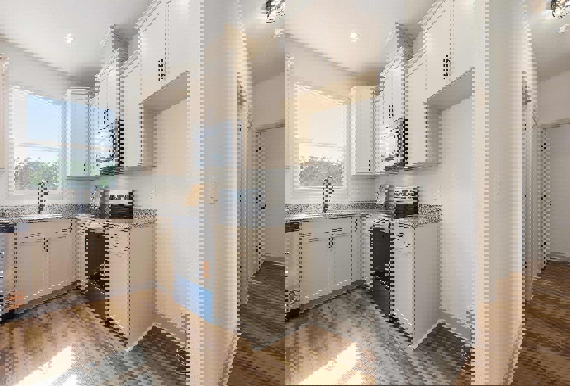 White kitchen cabinets, black appliances, window above sink with trees visible, black faucet, microwave oven, wooden cutting board with bow, close-up of cabinet door