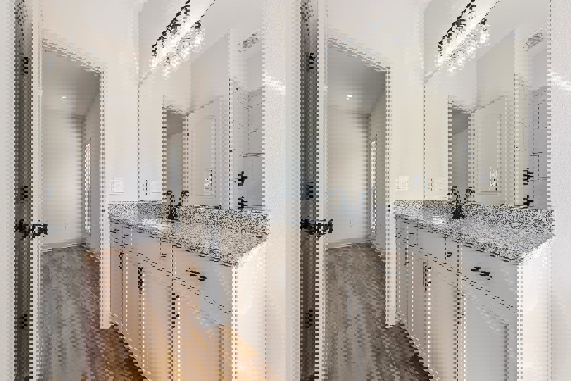 Bathroom with marble countertop, wood flooring, dark bar-mounted row of lights, white sink, and light fixtures on ceiling