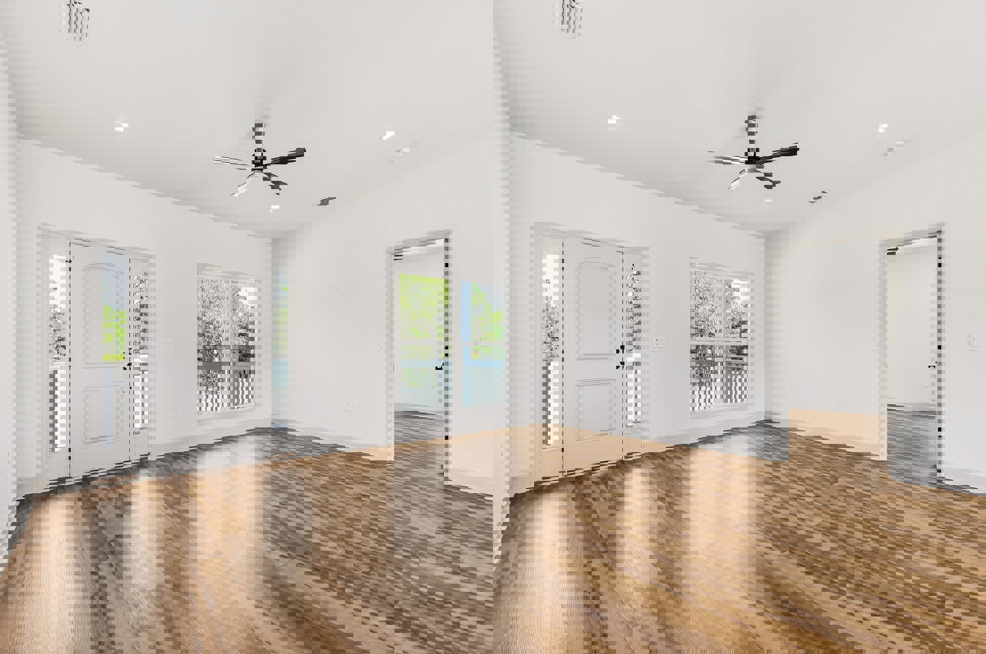 Wood flooring and white walls, ceiling fan with light fixture, white door with glass panes and black knobs, window overlooking balcony and trees.