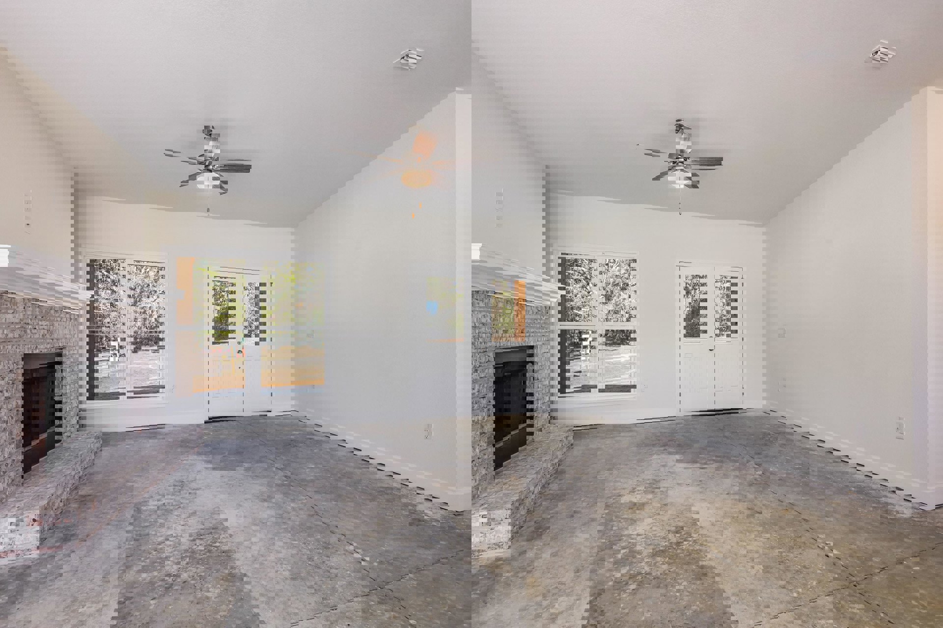 Open living area with wood flooring, ceiling fan with light, white plaster walls, black-screen fireplace, double glass doors, staircase with wooden railing, window showing trees