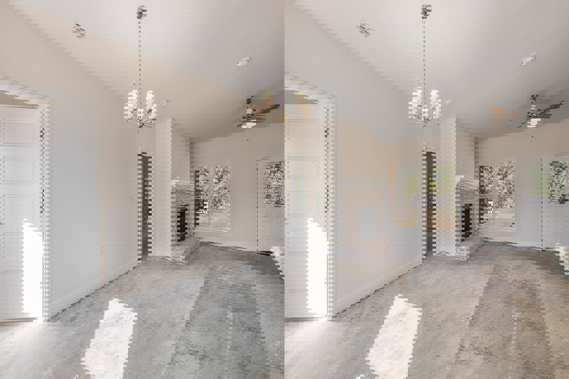 Living room with light-colored walls, white fireplace featuring a black screen, white door with a small hole, ceiling fan, and concrete flooring.