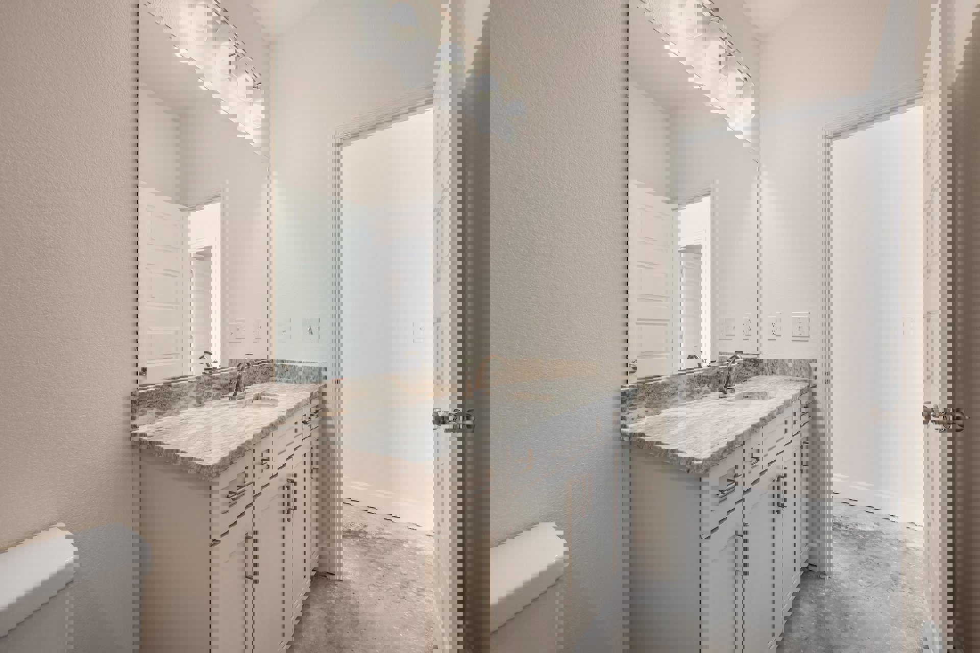 Bathroom featuring a marble countertop, large wall mirror, tile flooring, white cabinetry, wall-mounted light fixture, and a white door with a light switch.