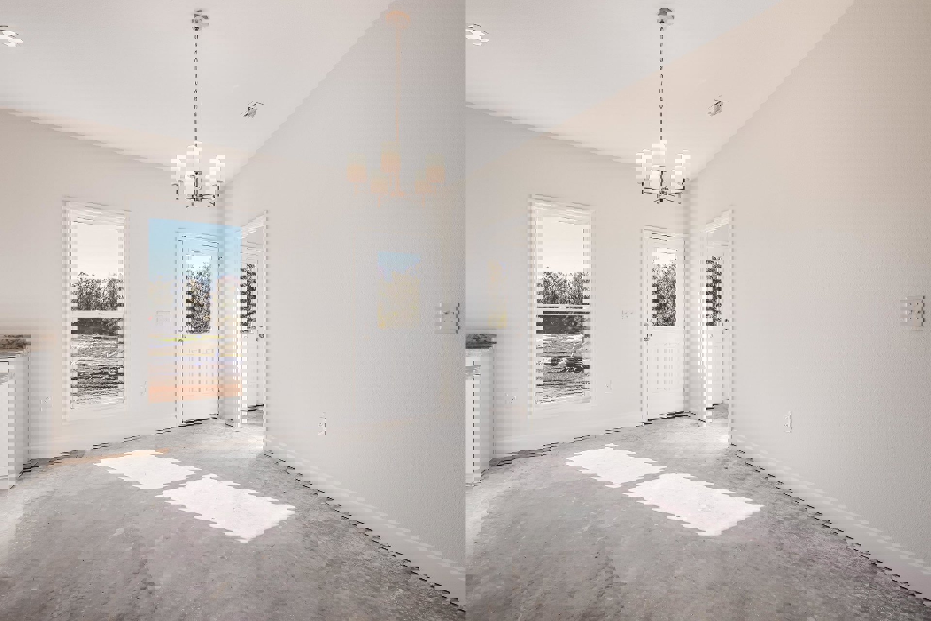 White-walled room featuring a ceiling light fixture, white door with glass window, light switch on the wall, and window overlooking a field and trees.