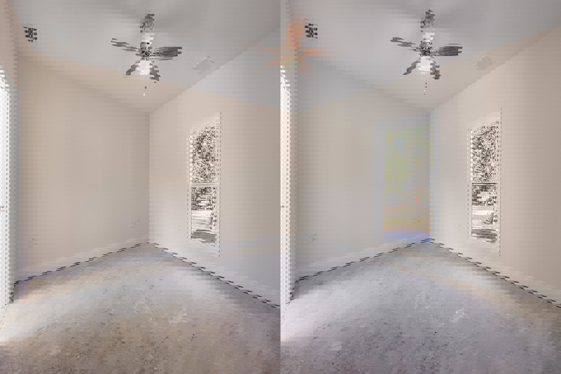 Ceiling fan with light fixture, large window showing trees and building, concrete floor, white plaster walls, wall and ceiling vents