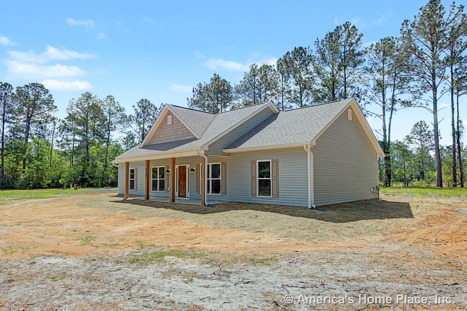 Covered front porch with wood column supports, double front entry door, vinyl siding exterior, gable shingle roof, multiple large windows, white trim, permanent lighting, and