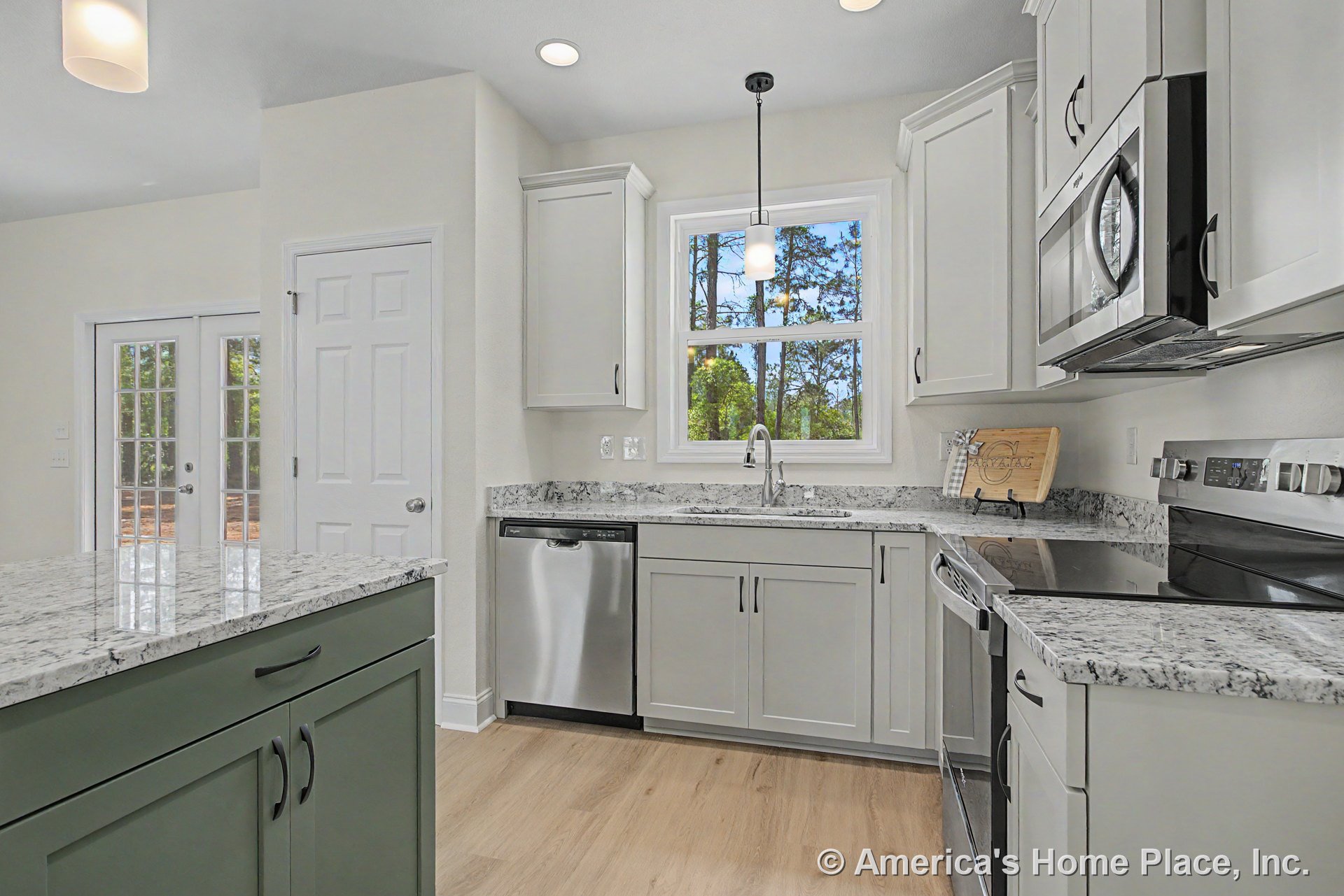 Shaker-style cabinetry with granite countertops, stainless steel dishwasher, microwave, and electric range; window above sink; pendant and recessed lighting; light wood flooring