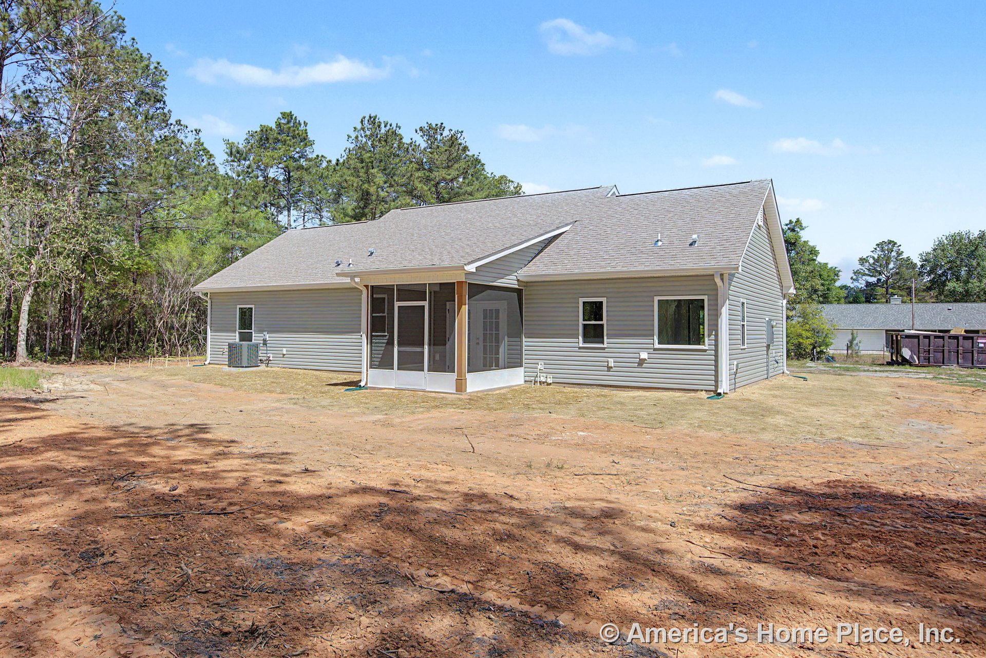 Screened porch with gray vinyl siding exterior, multiple windows, gable roof, exterior back door, and landscaped backyard area.