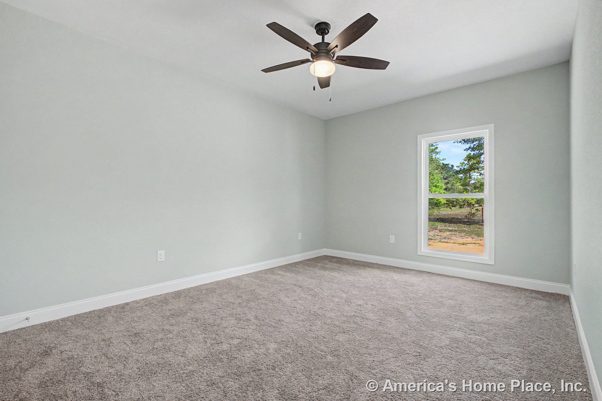 Bedroom with light gray carpet flooring, white baseboard trim, single rectangular window allowing natural light, ceiling fan with integrated lighting, light gray painted walls, and