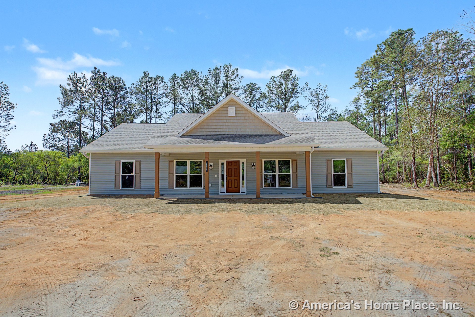 Covered front porch with four wooden columns, double front entry lights, multiple large windows, gable roof with vent, and horizontal siding exterior.