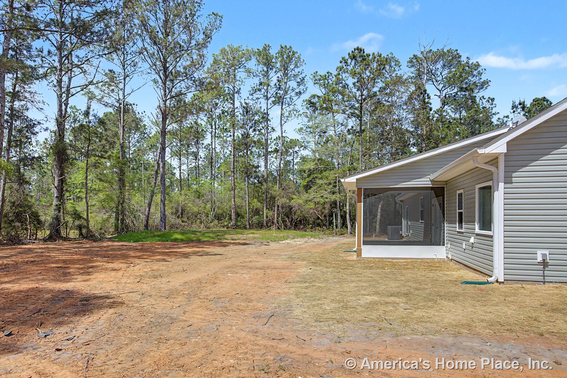 Screened-in porch with white trim attached to single-story exterior clad in gray vinyl siding, featuring multiple windows, sloped roof, gutter system, and landscaped yard.