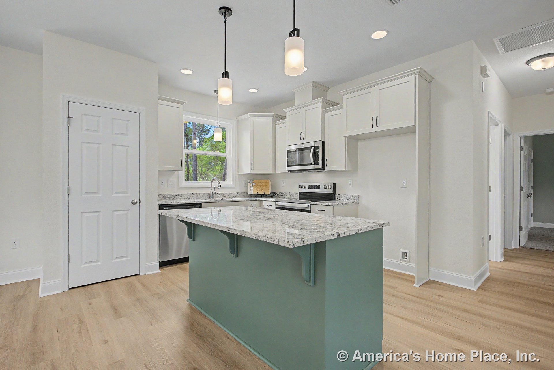 Central kitchen island with granite countertops, white shaker cabinets, stainless steel appliances, pendant and recessed lighting, wood-look flooring, built-in microwave, window