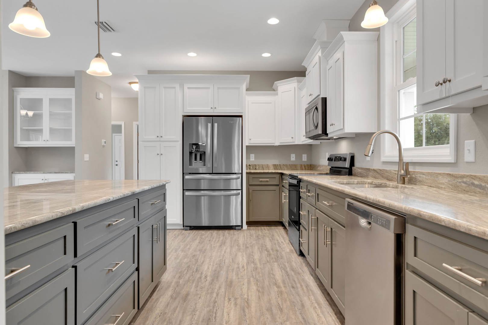 White kitchen with glass-front cabinets, stainless steel refrigerator and oven, wood flooring, open door, and modern light fixture
