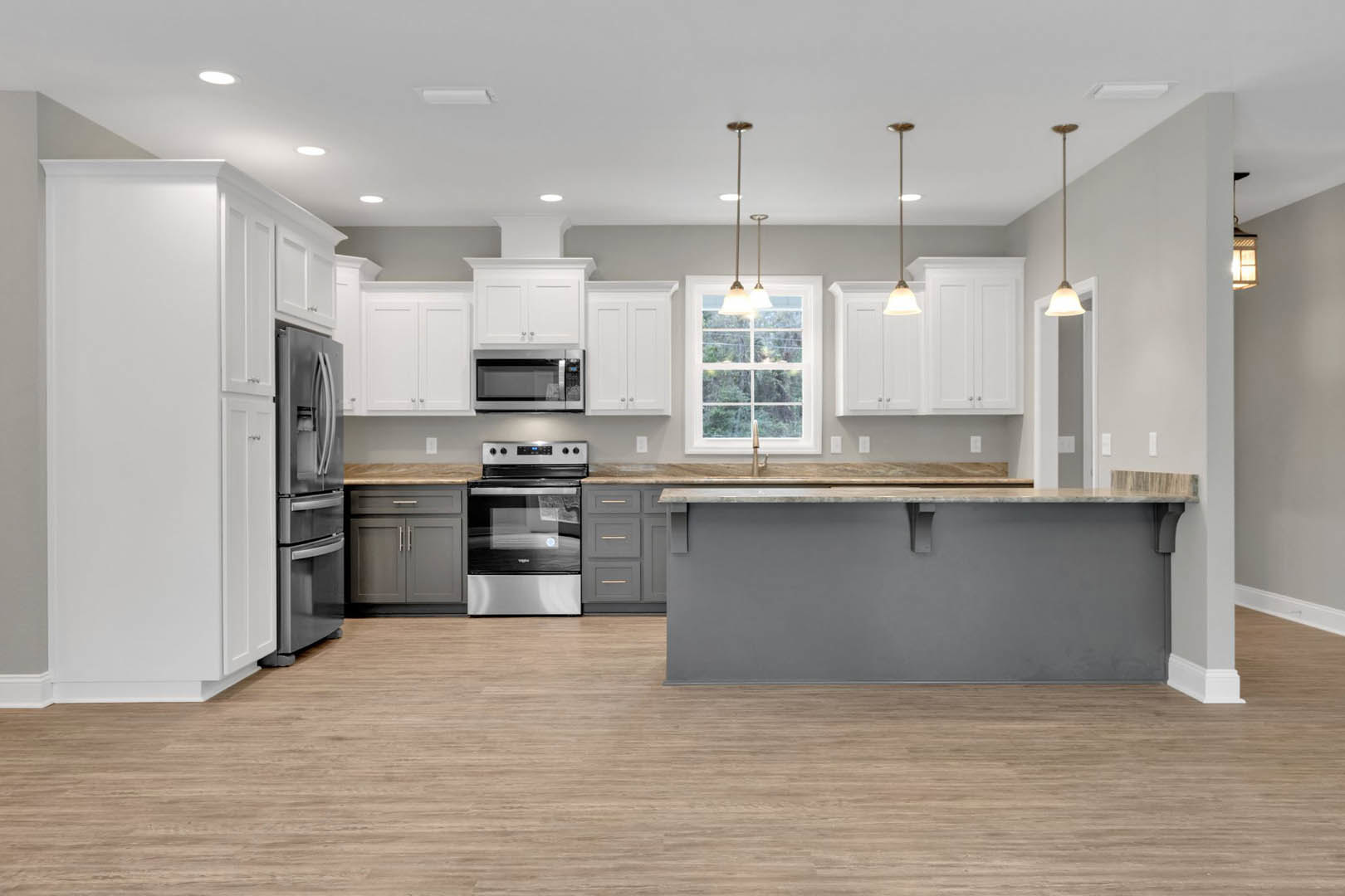 Open kitchen featuring a central island with grey countertop, stainless steel stove and oven, black and silver refrigerator, built-in microwave, tile flooring, white cabinetry, and
