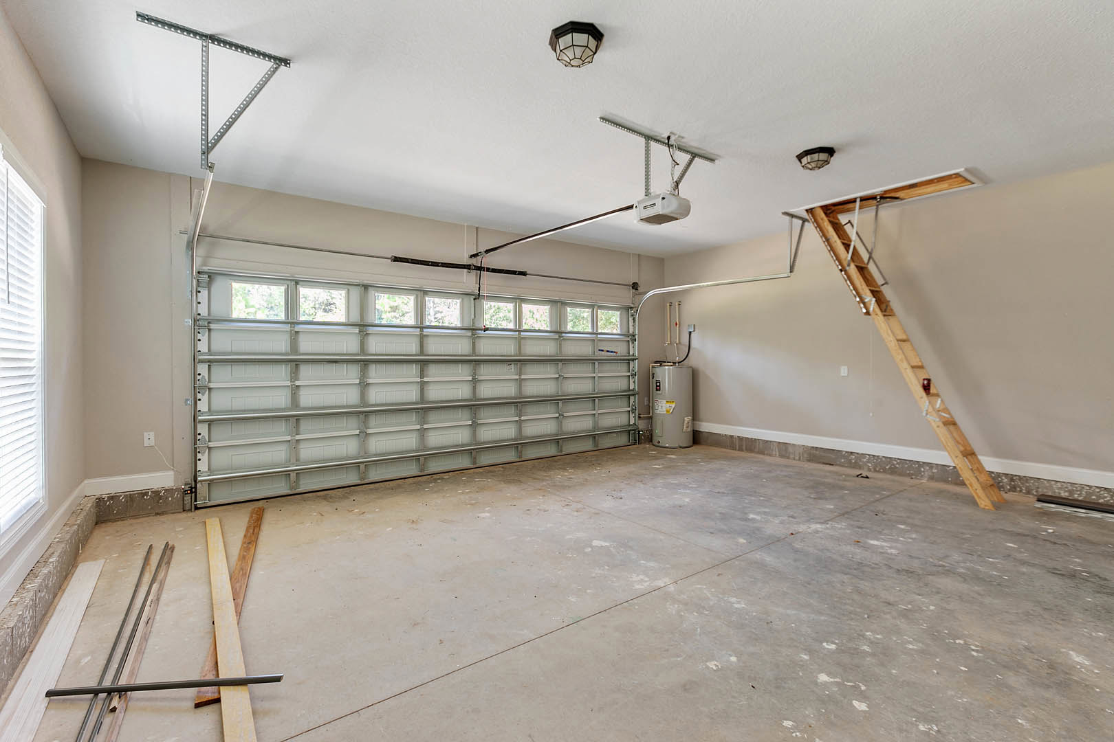 Garage interior with a metal ladder mounted on a plaster wall, white cylindrical object with yellow label, light fixture, multi-window garage door, and close-up of wooden plank.